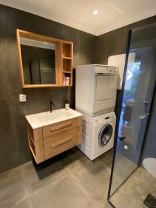 y baño con lavadora y lavamanos. en Moderne og velutstyrt leilighet nær sentrum, en Sandefjord