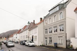 a row of buildings on a street with parked cars at Fresh studio apartment, a short walk from Bryggen in Bergen