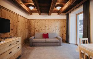 sala de estar con sofá y almohada roja en Alpin Chalet Samer Apt Berghütte, en Sarentino