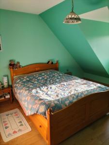1 dormitorio con cama de madera y pared azul en Sous le pommier, en Douvres-la-Délivrande