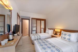 a hotel room with two beds and a flat screen tv at Labranda Mares Marmaris Hotel in Marmaris