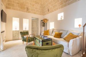 een woonkamer met een witte bank en stoelen bij Villa Perla del Mare in Carovigno