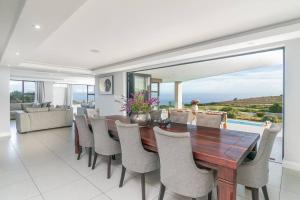 Un comedor con mesa y sillas de madera. en Paradise Views - Pezula Golf est, en Knysna