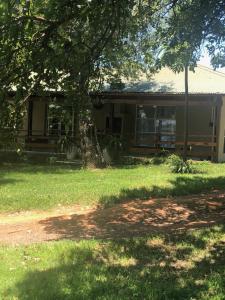 a house with a tree in front of it at Kieron's Cottage in Lydenburg