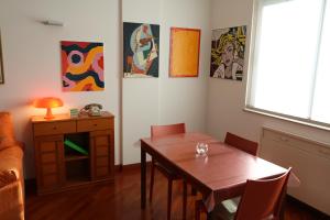 een eetkamer met een tafel en stoelen en schilderijen bij My Happy Place in Trieste