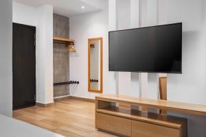 a living room with a large flat screen tv on a wall at The Bayou Hotel Langkawi in Pantai Cenang