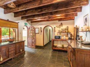 a large kitchen with wooden ceilings and wooden counters at Lapalosa Lodge in Centurion