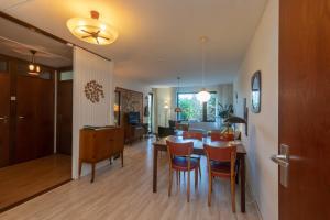 een eetkamer en een woonkamer met een tafel en stoelen bij Appartement - Kievitenlaan 1 - Veere 'Nescio' in Veere