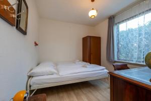 een kleine kamer met een bed en een raam bij Appartement - Kievitenlaan 1 - Veere 'Nescio' in Veere