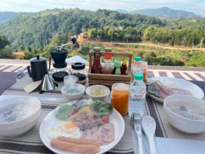 a table with plates of food and drinks on it at Green bus view inside hills khaokho in Khao Kho