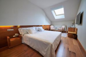 a bedroom with a large white bed with a skylight at Gran Hotel La Perla in Pamplona