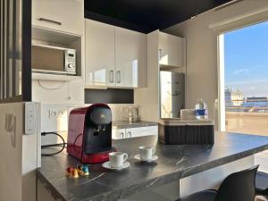 uma cozinha com um balcão e comodidades para preparar café em Peri - Lit Kingsize - Terrasse vue Tour Eiffel #SirDest em Bezons