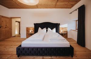 a bedroom with a large bed with white sheets at Alpin Chalet Samer Apt Bauernstube in Sarntal