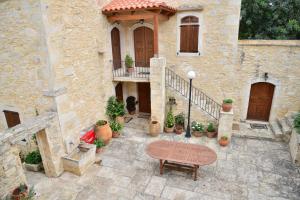 a stone house with a bench in front of it at Allaria villa in Margarítai