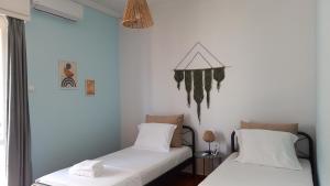 2 camas en una habitación con paredes blancas en Kiani Apartment, en Preveza