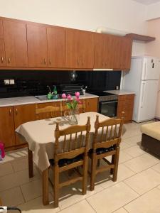 eine Küche mit einem Tisch und Stühlen sowie einem weißen Kühlschrank in der Unterkunft warm home in Koropi