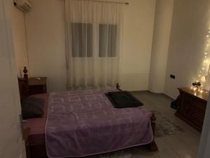 ein Schlafzimmer mit einem lila Bett und einem Fenster in der Unterkunft warm home in Koropi