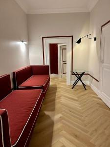 uma sala de estar com um sofá vermelho e uma mesa em Relais Della Porta em Nápoles