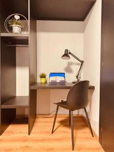 einen Schreibtisch mit einem Laptop und einem Stuhl in einem Zimmer in der Unterkunft House 74 in Verona