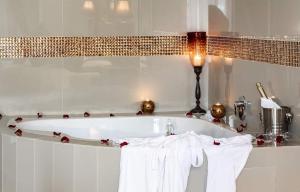 een badkamer met een bad en witte handdoeken bij Ridgeworth Boutique Guesthouse in Bellville