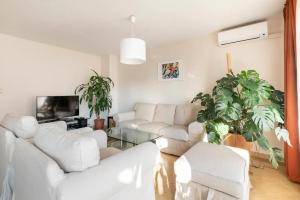 un soggiorno con divani bianchi e piante in vaso di 2BDR Duplex Apartment with Parking a Sofia