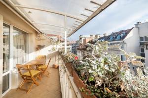 a balcony with a table and chairs and a plant at 2BDR Duplex Apartment with Parking in Sofia