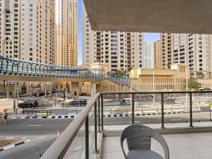 a chair on a balcony with a view of a city at Charming & Vibrant 1Bedroom In Marina Quay in Dubai