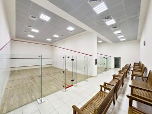 a gym with a tennis court in a building at Charming & Vibrant 1Bedroom In Marina Quay in Dubai