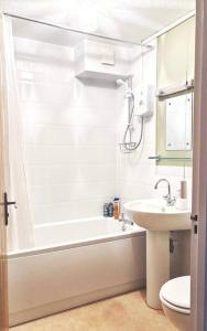 ein Badezimmer mit einer Badewanne, einem Waschbecken und einem WC in der Unterkunft Apartment in Epsom With Free Parking in Epsom