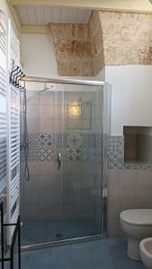 y baño con ducha de cristal y aseo. en Palazzo Ferilli Alfonso, en Ruffano