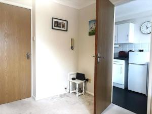 a kitchen with a white refrigerator and a clock on the wall at Apartment in Epsom With Free Parking in Epsom