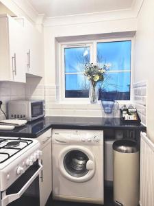 eine Küche mit einer Waschmaschine und einem Fenster in der Unterkunft Apartment in Epsom With Free Parking in Epsom