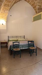 1 dormitorio con 1 cama con 2 sillas en Palazzo Ferilli Alfonso, en Ruffano