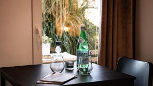 a bottle and two glasses on a table at Apartments & Rooms Buble in Trogir