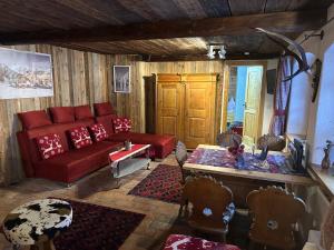 ein Wohnzimmer mit einem roten Sofa und einem Tisch in der Unterkunft Designer-Chalets in Dienten am Hochkönig