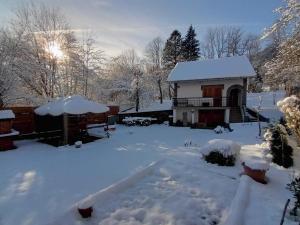 a house covered in snow with a hot tub at Kuća za odmor Denis in Mala Lešnica