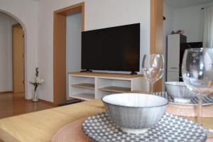 a living room with a television and two wine glasses at Ferienwohnung Kraus 2-4 Pers in Herbolzheim
