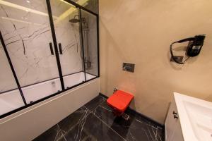 a bathroom with a shower and a red stool at MATEO HOTEL in Istanbul