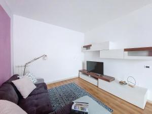 sala de estar con sofá y TV de pantalla plana en Giuly House en Arenzano