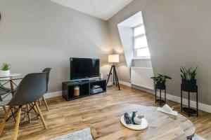 uma sala de estar com uma mesa e uma televisão em 2 Bedroom Flat, Wembley Stadium em Londres