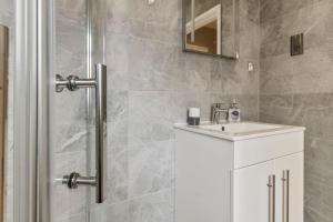 a bathroom with a white sink and a shower at 2 Bedroom Flat, Wembley Stadium in London