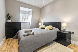 - une chambre avec un lit avec deux oreillers et un miroir dans l'établissement 2 Bedroom Flat, Wembley Stadium, à Londres