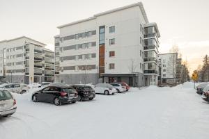 un estacionamiento con autos estacionados en la nieve en Kokonainen huoneisto 73m2 keskeisellä sijainnilla, ilmainen parkkipaikka, en Lahti