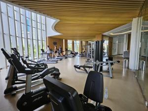 a gym with a lot of treadmills and people in the gym at 3BR Flat in Taman Anggrek Residence in Jakarta