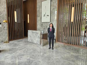a woman standing in the lobby of a building at 3BR Flat in Taman Anggrek Residence in Jakarta