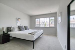 a white bedroom with a bed and two windows at Milpitas 2br w backyard pool nr park trails SFO-1604 in Milpitas