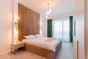ein Schlafzimmer mit einem großen Bett und einem großen Fenster in der Unterkunft WAVE 4 Apartments Mamaia Nord in Năvodari + 118 Fotos
