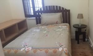 a bed with a bedspread with flowers on it at Tita comfortable home in Johannesburg