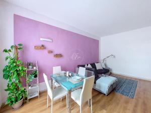 comedor con mesa y pared púrpura en Giuly House, en Arenzano