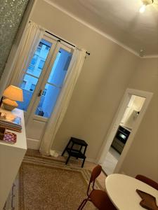 salon ze stołem i oknem w obiekcie Casa di Leonardo Elegant & Comfort w mieście Bari
